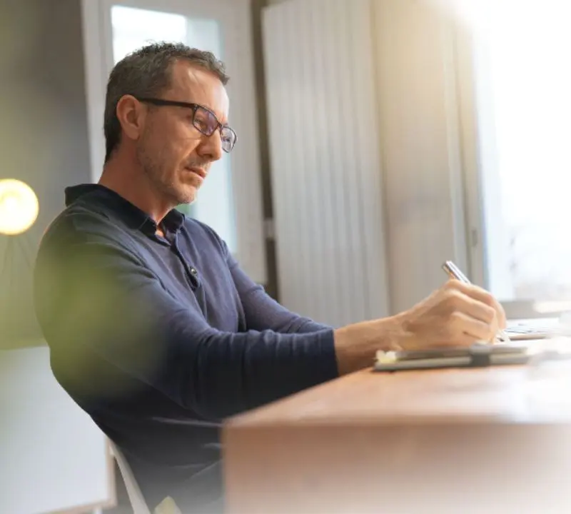 Man sitting at desk with pen.